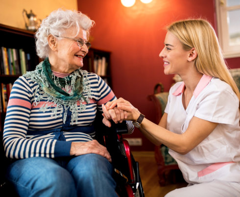 portrait of happy nurse and patient on wheelchair