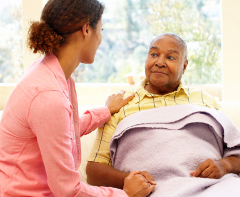 caregiver with her patient resting on bed