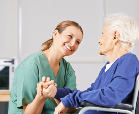 portrait of happy nurse and patient holding hands together