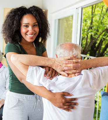 caregiver helping senior man on therapy