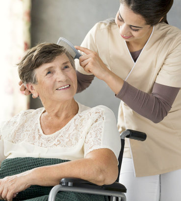 caregiver combing the hair of her patient