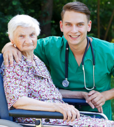 smiling nurse with his patient on wheelchair